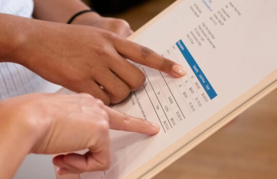 persons pointing at the numbers on the invoice